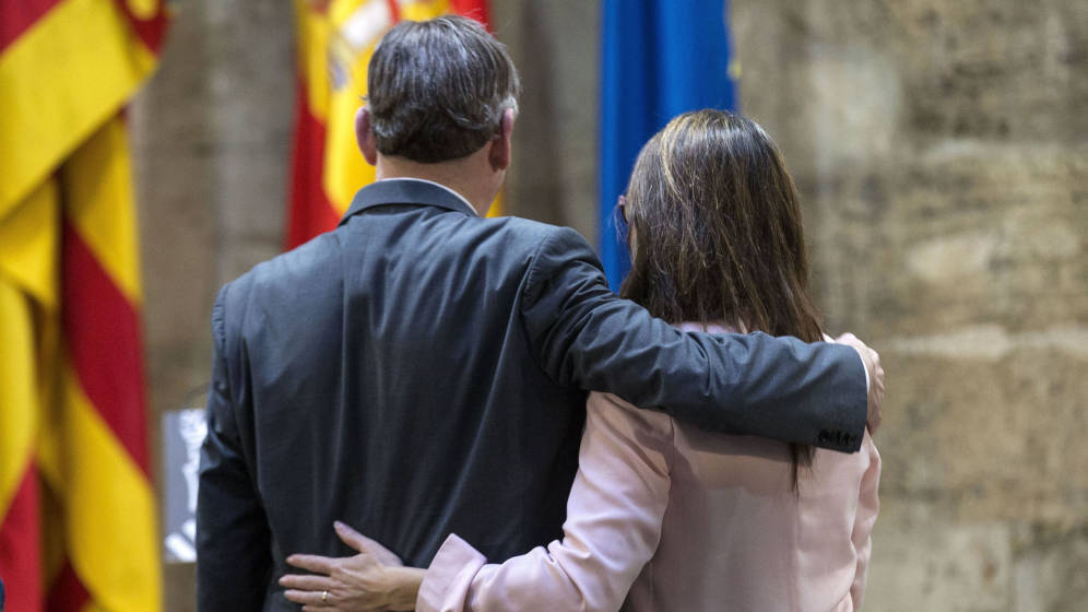 Ximo Puig y Mónica Oltra, abrazados en un acto en el Palau. Foto: EFE