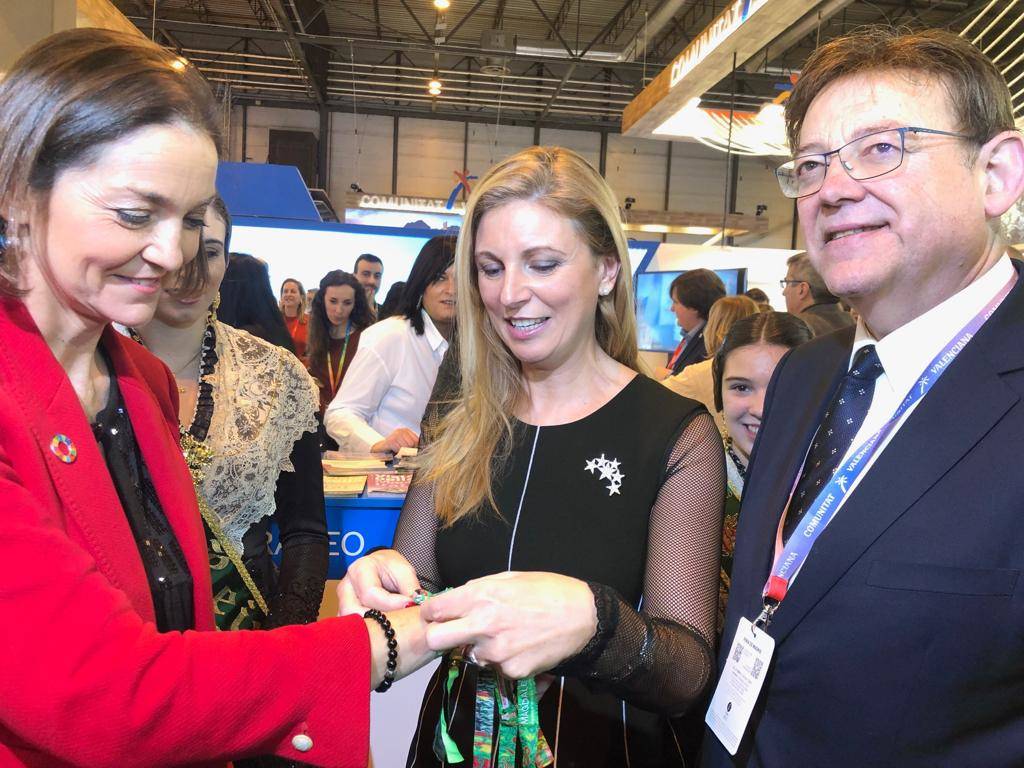 La alcaldesa coloca la pulsera de la Magdalena a la ministra Reyes Maroto.