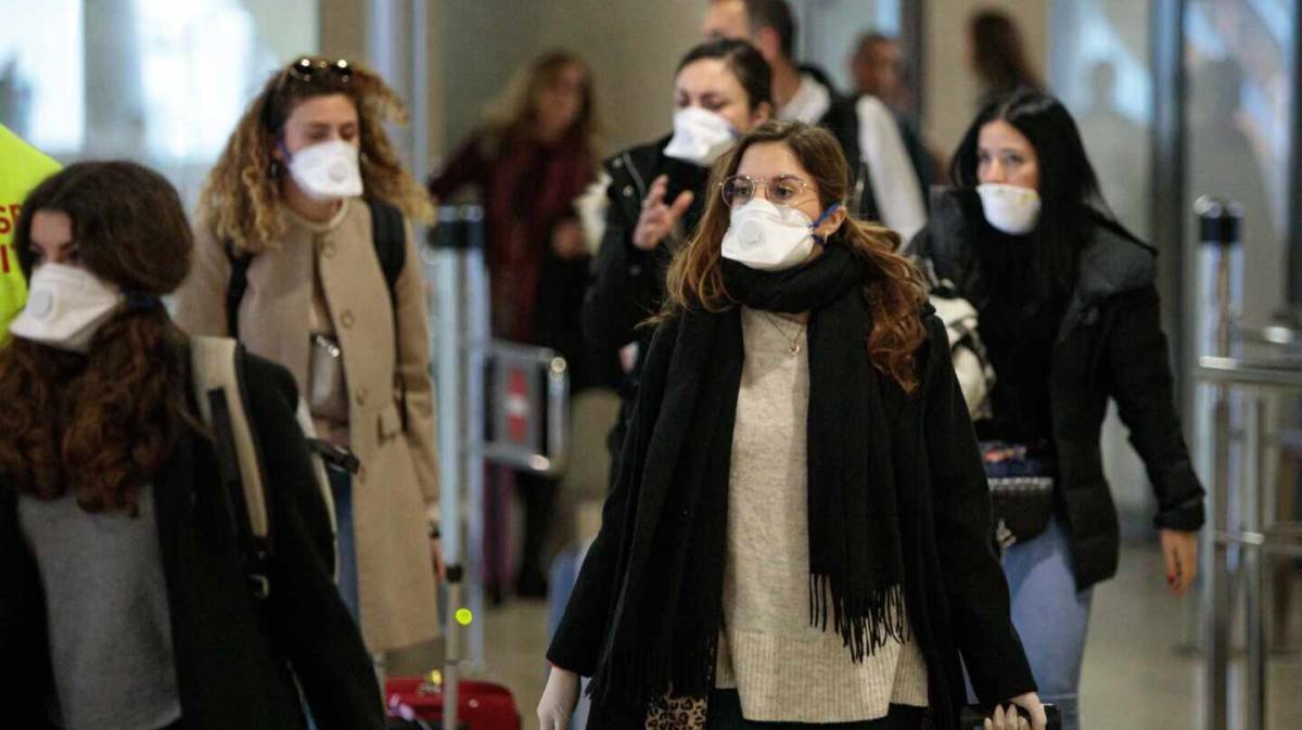 Viajeros procedentes de Italia protegidos con mascarillas a su llegada al aeropuerto de Manises (Valencia). EFE/ Biel Aliño