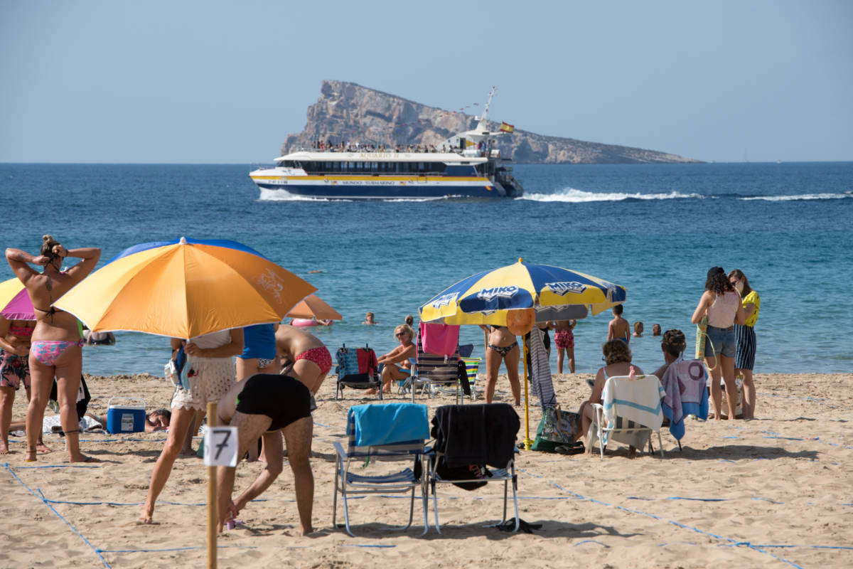 Turistas en las parcelas de la playa de Levante de Benidorm, este domingo