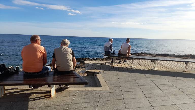Cuatro turistas observan el mar en Torrevieja, la semana pasada. 