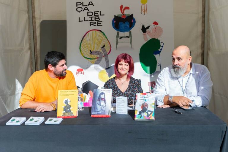 D'esquerra a dreta: Vicent Baydal, Carme Cardona i Enric Nomdedéu, signant exemplars de les seues obres 