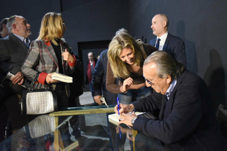  Manu Vives, de pie a la derecha, mientras Carlos Fabra firma su libro a Esther Pallardó. Foto: CARLOS PASCUAL