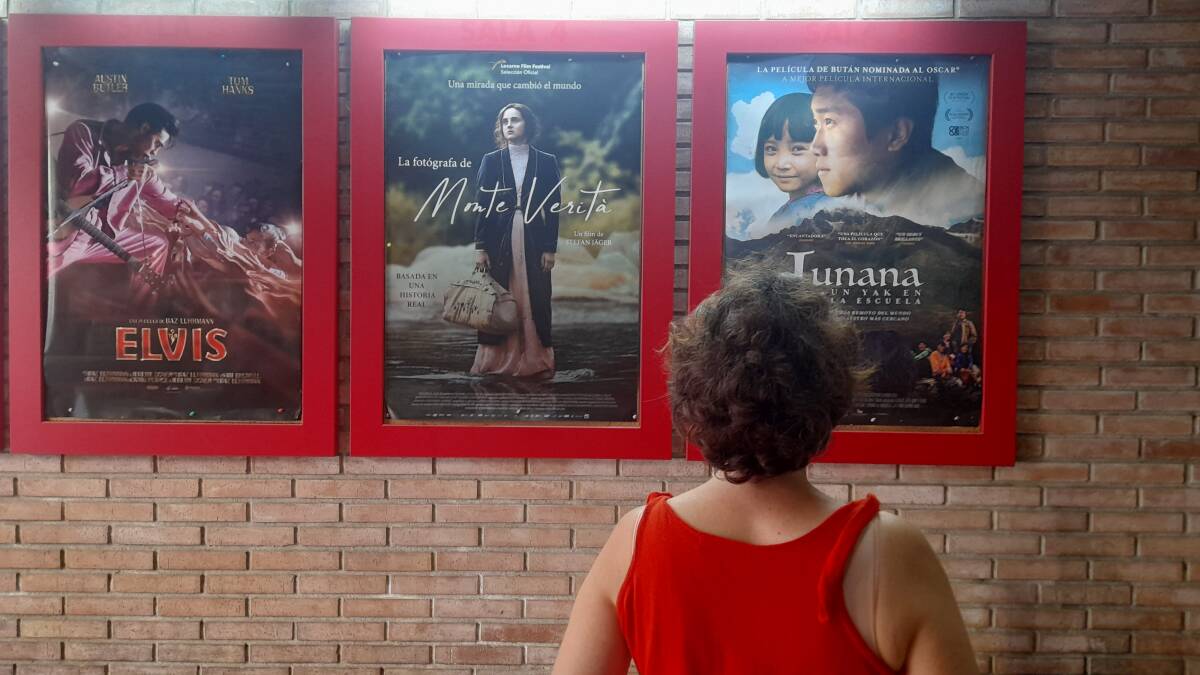 Una espectadora mira el cartel de la película 'Lunana, un yak en la escuela, en los cines Babel, en Valencia. Foto: Javier Carrasco