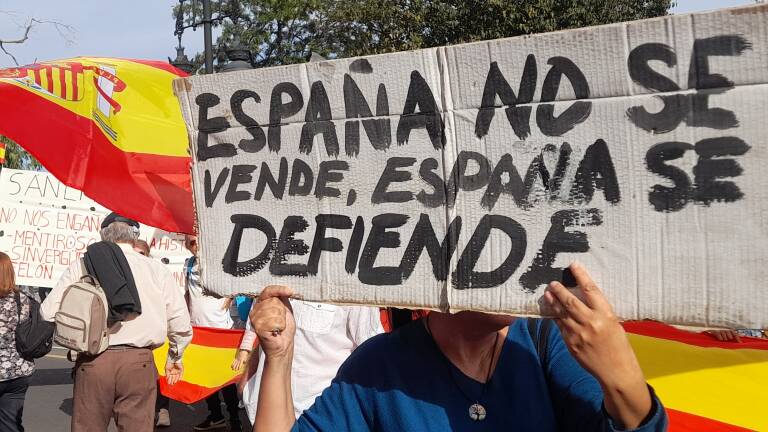 Una mujer sujeta un cartel en una concentración contra la amnistía, en València.