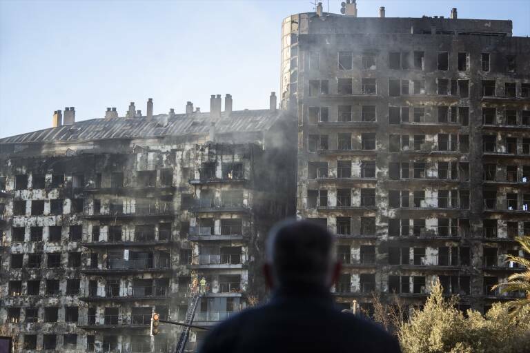 Un hombre observa el esquelo del edificio quemado. Foto: JORGE GIL/EP