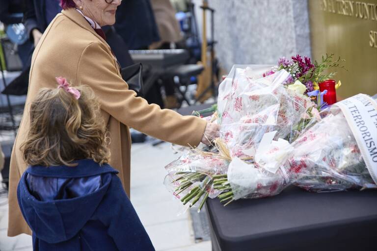 Varias personas dejan flores en 2023 frente a la placa durante un acto por el 11M. Foto: JESÚS HELLÍN/EP